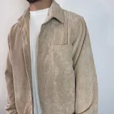 Sobrecamisa color beige de pana con cuello clásico, cierre abotonado y bolsillo de parche en el pecho.