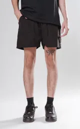 Short de baño negro con diseño funcional y bolsillos laterales.