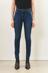 Jean slim de denim azul con lavado localizado y detalles de hot fix en los bolsillos delanteros.