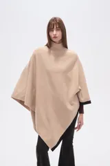 Poncho beige de poliéster con cuello alto y terminaciones en negro.