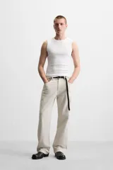 Pantalón de jean color beige, corte recto y relajado, con cintura ajustable con cordón interior, cinco bolsillos, efecto lavado y cierre frontal con cremallera y botón.
