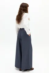 Pantalón culotte azul piedra, de tiro alto, con pinzas en la cintura y piernas anchas. Presenta sutiles rayas bordó y bolsillos laterales.