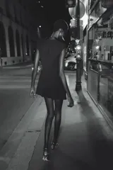 Mono corto negro con cuello smoking satinado, sin mangas y hombreras. Presenta detalle de frunce en la cintura y cierre cruzado con botones a presión.