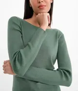 Suéter de punto color verde, con cuello barco, mangas largas y textura acanalada.