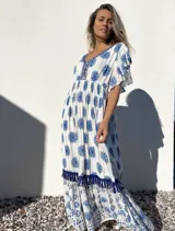 Vestido largo blanco con estampado floral azul, escote en V con bordado y mangas cortas con volados.