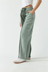 Pantalón verde con corte ancho, bolsillos laterales y cintura ajustable con cordón.