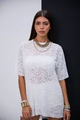 Remerón de encaje blanco con cuello redondo y mangas cortas.