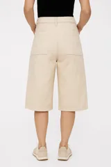 Bermuda de jean color beige, corte amplio y largo hasta la rodilla.