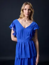 Vestido blanco de gasa con capas de la marca Julia Jordan. Tiene escote en V, mangas cortas con volados, corte en la cintura, abertura central en la espalda con cierre invisible y forro interno a tono.
