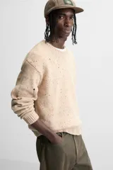 Sweater color beige con detalles de roturas y agujeros.