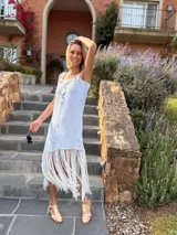 Vestido corto tejido en lurex con diseño geométrico en cuero en el frente, breteles de cuero intervenido a mano con tientos de cuero plateado y terminación en flecos.