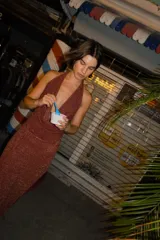 Falda larga tejida color vino tinto con brillo dorado, de corte ajustado y abertura lateral en la pierna.