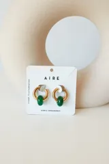 Aros de acero quirúrgico hipoalergénico con piedras naturales azules. Diseño de aro con dije circular colgante.