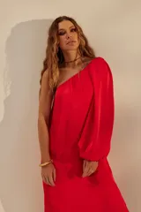 Vestido largo rojo de un solo hombro, con manga larga abullonada y tajo lateral.