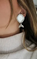 Aros plateados con forma circular y colgante con forma de gota.