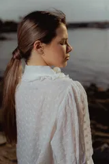 Blusa blanca de algodón bordado con cuello con volados y lazo.