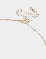 Cadena corta dorada con dije de corazón entrelazado con el símbolo de infinito, ambos adornados con strass.