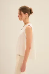 Musculosa blanca de algodón con cuello redondo y sisas amplias.