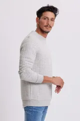 Buzo gris melange de corte clásico con textura capitoneada.