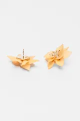 Par de caravanas con forma de flor color durazno y centro con apliques de strass.