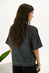 Blusa color crudo de lino con cuello redondo y mangas cortas.