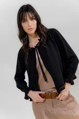 Saco tejido color negro con detalle en escote y puños a dos tonos, corte acampanado y detalle en la espalda con cambio de punto y color.