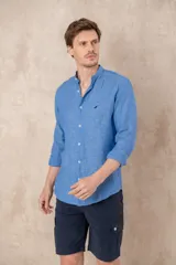 Camisa celeste de lino con cuello mao, corte slim fit, manga larga con puños abotonados y cierre frontal con botones.