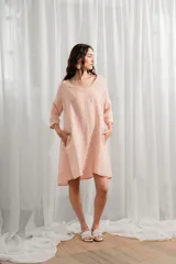 Vestido corto de lino color rosado, corte ancho y mangas 3/4, con escote en V.