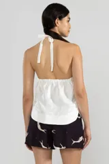 Top halter blanco de lino italiano con hilo metalizado y escote con cordón ajustable.