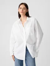Camisa de popelina a rayas verticales rosas y blancas, de corte holgado y manga larga.