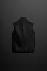 Chaleco negro de tejido técnico con estructura ripstop y ligero acolchado interior. Cuello alto ajustable con elástico, sisas amplias, bolsillos de seguridad con cremallera en pecho y cadera, acabados con cinta elástica, cierre frontal con cremallera y logo estampado en el bajo.