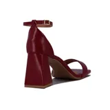 Sandalia de tacón alto color blanco, con una tira delgada sobre los dedos y pulsera con hebilla al tobillo.