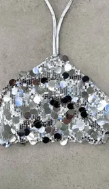 Top plateado con lentejuelas, de corte halter y espalda descubierta.