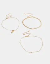Set de tres gargantillas doradas de diferentes diseños: una con dije de serpiente, otra de eslabones planos y otra con pequeñas esferas.