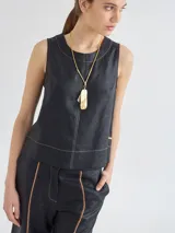 Top color beige de lino y viscosa, corte recto y escote redondo con cierre a la vista en la espalda y pespuntes a contratono.