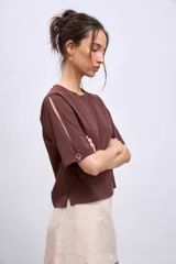 Remera blanca de algodón con cuello redondo y mangas cortas con aberturas laterales.