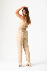 Pantalón color beige con finas líneas verticales blancas, tiro alto y corte palazzo.