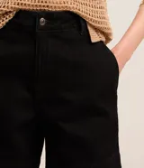 Short de jean azul de tiro alto, con bolsillos delanteros y traseros, trabillas y ruedo desflecado.