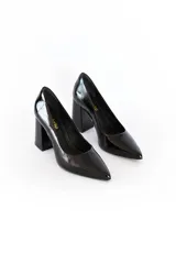 Zapato de tacón alto color negro charol, con punta fina y logo dorado en el interior.