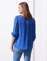 Blusa verde agua de gasa marca Figueroa & Flower, con cuello redondo y aplique de crochet. Tiene mangas 3/4 amplias con puño y botón, y forro interno a tono.