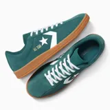 Championes Converse All Star Classic Trainer Ox, color verde oscuro, con logo estrella y chevron en blanco y cordones blancos. Suela de goma color caramelo.