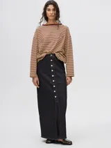 Falda midi de denim color marrón con hilado a la vista en el ruedo y abotonadura frontal.