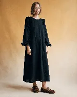 Vestido midi negro de algodón con textura de lunares en relieve, escote redondo, mangas largas con volados en los hombros y puños elásticos con volados.