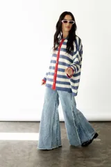 Camisa de algodón a rayas horizontales azules y blancas, con cuello camisero, cierre frontal con botones y mangas largas.