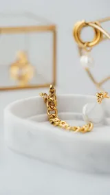 Pulsera dorada de acero quirúrgico con cadena de eslabones gruesos y dos perlas de agua dulce. Tiene cierre de mosquetón y cadena de alargue.