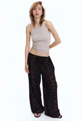 Pantalón de punto de corte holgado con piernas amplias, tiro alto, cintura elástica y cordón para ajustar.