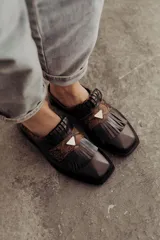 Zueco de cuero color crudo con detalle de flecos y pieza central en cuero snake.