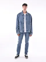 Campera de jean negra con cuello clásico, cierre frontal con botones metálicos, bolsillos con solapa en el pecho y corte recto.