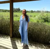 Vestido largo celeste de lino italiano, con escote en V, mangas cortas y bolsillos laterales.