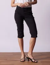 Pantalón capri blanco de algodón elastizado. Pretina con pasadores, botón y cierre. Delantera con bolsillos. Trasera con bolsillos simulados.